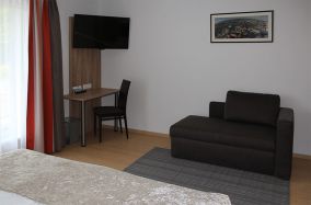 TV und ausziehbare Couch im Apartment 03
