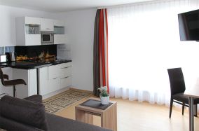 Miniküche mit Esstisch und Fernseher im Appartment 01