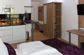 Apartment 02 mit Miniküche, Schrank, Schreibtisch und Fernseher